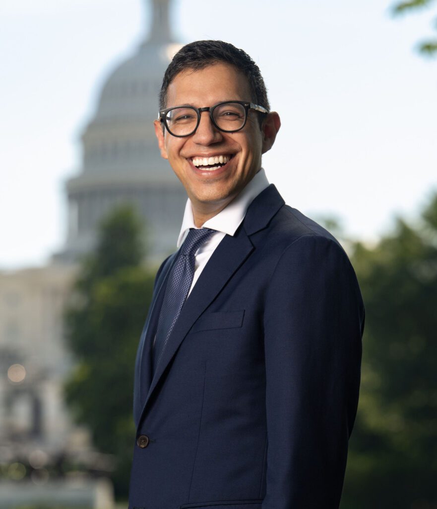 Professional headshot with US Capitol dome backdrop